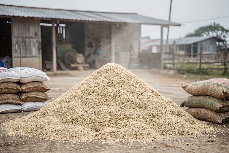 A pile of rice husks beside a rural rice mill